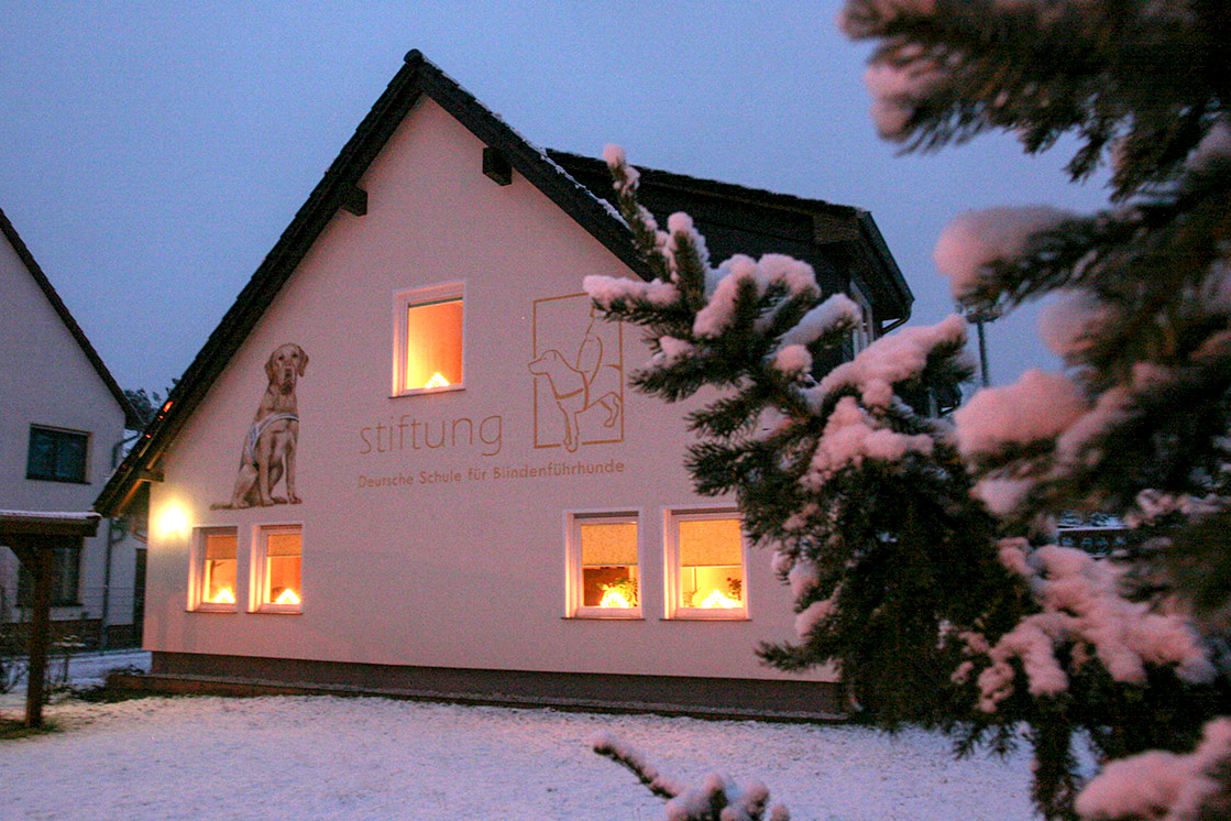 Das Haus der Stiftung leuchtet im Winterschnee.